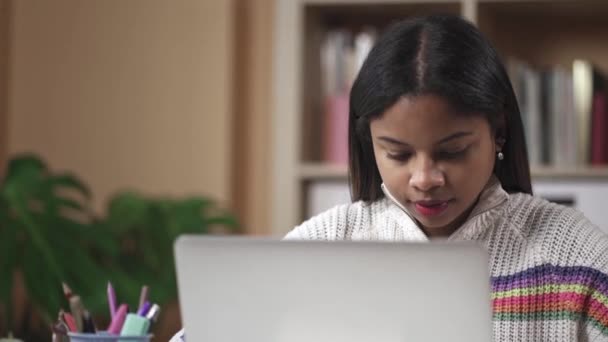 Giovane studentessa nera dell'Università che studia al computer a casa. Casual ragazza concentrata che lavora sul computer portatile, scrivere e-mail — Video Stock