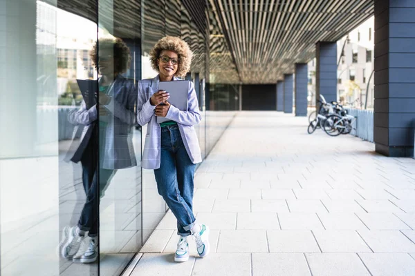 Muotokuva Young African American nainen johtaja uusi luova moderni yritys seisoo ulkona toimistotila kannettavan tietokoneen — kuvapankkivalokuva