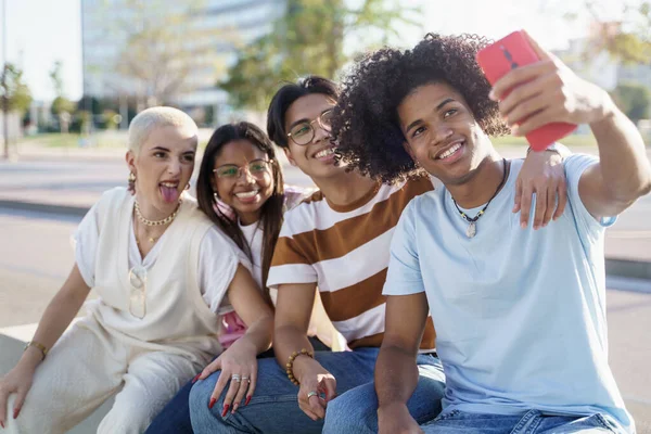 Svart, ung mann med afrofrisyre tar selfie med en gruppe av diverse gen- z-tenåringsvenner – stockfoto