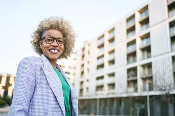 Musta nainen Real State agentti seisoo edessä sosiaalisen asuntotuotannon huoneisto — kuvapankkivalokuva