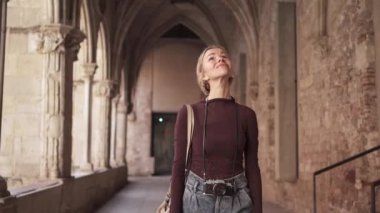 Klasik kameralı kadın turist Avrupa 'daki antik manastır kilisesini ziyaret ediyor ve keşfediyor.