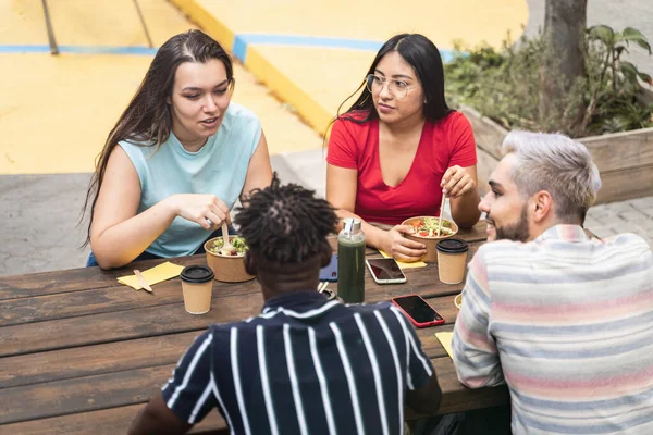Молоді друзі їдять їжу і працюють разом під час перерви на роботі — стокове фото
