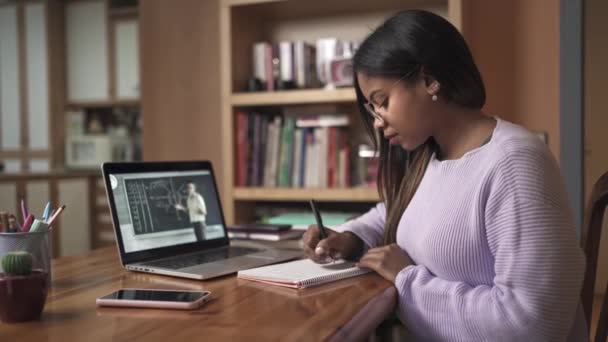 Jovem estudante negro feminino assistindo aula on-line com professor de matemática. Menina Estudando e tomando notas de casa Educação Online e e-learning — Vídeo de Stock