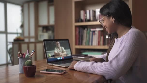Weibliche schwarze Lateinstudentin, die von zu Hause aus Videotelefonie mit dem Lehrer der Universität lernt. Online-Bildung — Stockvideo