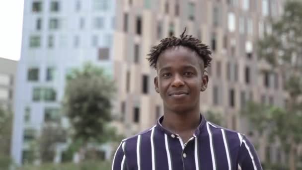 Porträt eines selbstbewussten jungen schwarzen Afrikaners, der in einer modernen Geschäftsstadt unterwegs ist — Stockvideo