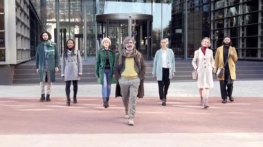 Çok Kültürlü Yaratıcı İş Adamları, iş yerinin dışındaki pazarlama reklamcılarının açık hava portresi kameraya doğru yürüyorlar.