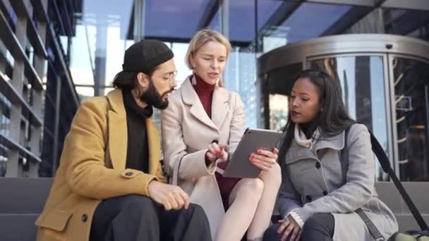 Tim rekan bisnis menggunakan tablet digital untuk mendiskusikan ide-ide tentang proyek di luar tempat kerja — Stok Video