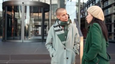 Bayan iş arkadaşları kışın iş yerinin dışında konuşmaktan zevk alıyorlar. Kadın iş arkadaşları iş arasında projeler hakkında konuşuyor.