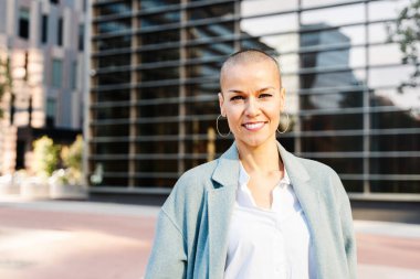 Ortak ofis alanında modern iş kadınlarının portresi. Güçlü, kısa saçlı, kameraya bakan bir kadın.