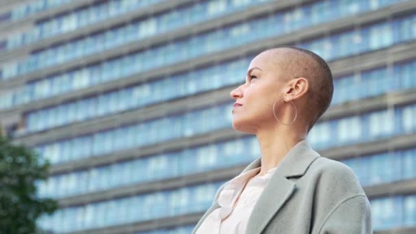 Stylová obchodní žena s vyholenými vlasy se dívá do kamery s sebevědomým výrazem. Lidské emoce a pocity, boj proti rakovině a chemoterapii