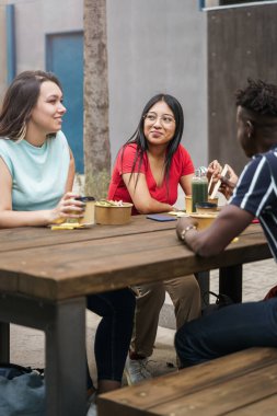 Genç arkadaşlar yemek yiyor ve iş arasında birlikte çalışıyorlar.