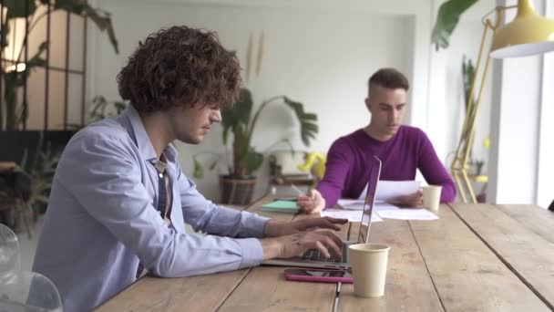 Jeune couple gay lisant de bonnes nouvelles dans le document, souriant excité par lettre postale, vérifier le paiement des factures domestiques en ligne sur ordinateur portable, discuter de la planification budgétaire — Video
