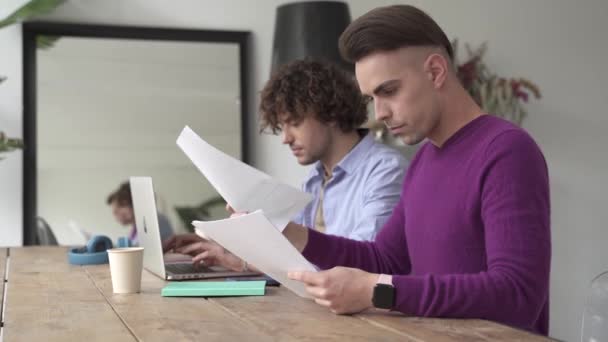 Couple gay masculin travaillant sur les finances et la paperasserie à la maison, calculant le budget pour la vie domestique — Video