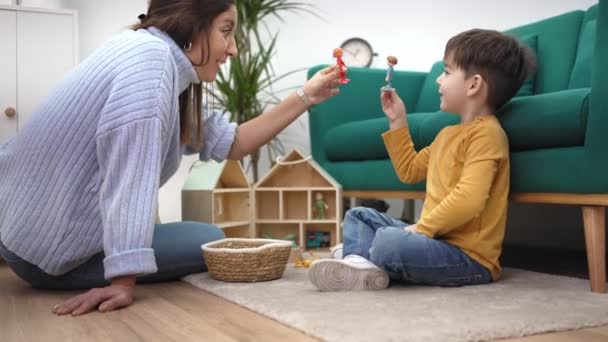 Educatieve therapeut spelen spel met klein kind met houten speelgoed om hem te helpen om zijn gedrag en geestelijke gezondheid te verbeteren — Stockvideo