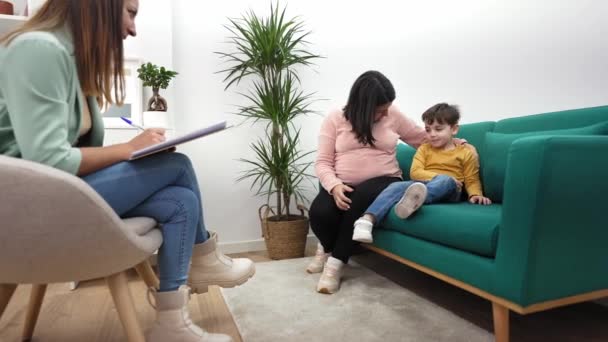 Zwangere moeder met haar zoon bij kinderpsychologen. Kinderen therapeut verzorgen van kinderen behandeling voor geestelijke gezondheid — Stockvideo