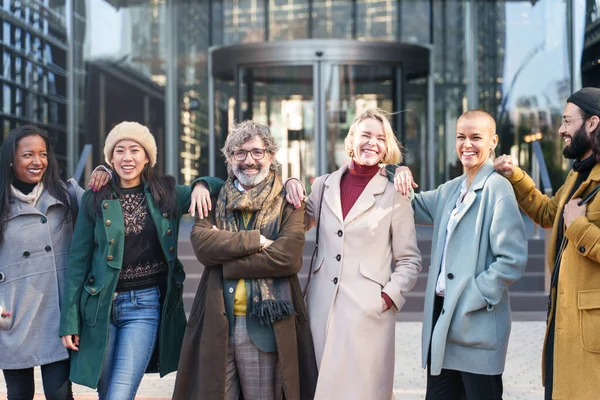 Lykkelig team av elegante fagfolk som omfavner og smiler utenfor arbeidsplassen. Samarbeid, samarbeid og suksesskonsept – stockfoto