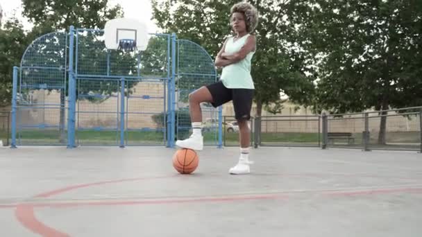 Mulher afro-americana engraçada em sportswear com bola esporte ao ar livre campo de basquete — Vídeo de Stock