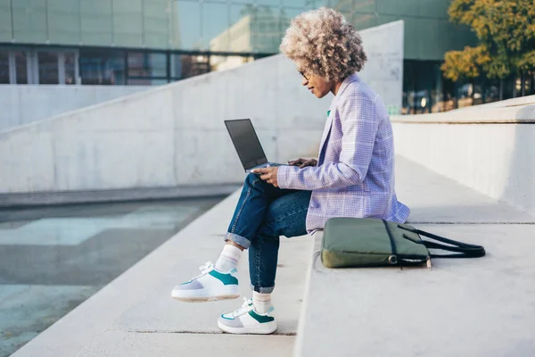 Entreprenørkvinne for svarte kvinner som jobber med en bærbar PC og skriver e-post utendørs i byen – stockfoto