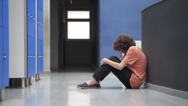 Triste adolescent étudiant assis seul sur le sol victime d'intimidation et de bons camarades de classe amis l'aider et le consoler. Empathie et soutien dans l'éducation — Video