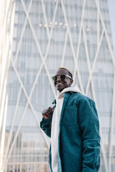Muotokuva modernin luottavainen musta Afrikkalainen mies aurinkolasit ja huppari kaupungissa — kuvapankkivalokuva