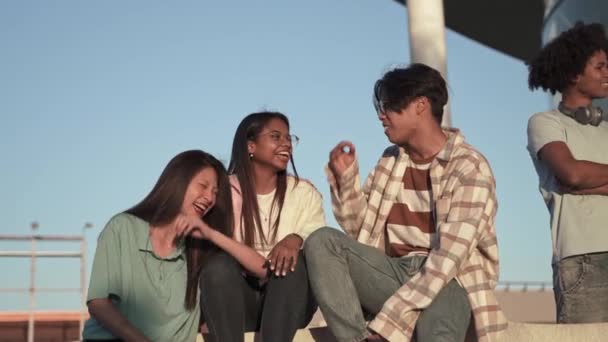 Έφηβοι Ασιάτες και Λατινοαμερικανοί φίλοι διασκεδάζουν, γελάνε και χαλαρώνουν μαζί — Αρχείο Βίντεο