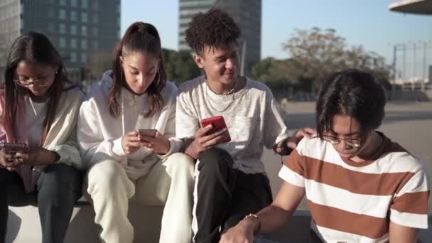 Ομάδα χαρούμενων εφήβων φίλων που χρησιμοποιούν τα κινητά τους τηλέφωνα για να μοιραστούν αστείες στιγμές — Αρχείο Βίντεο