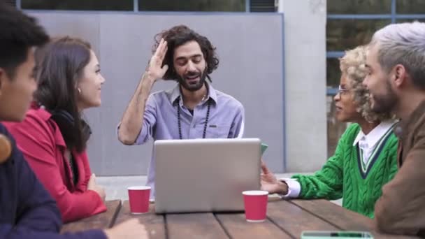 Jovens colegas criativos empreendedores tendo reunião informal ao ar livre para discutir o projeto. Amigos trabalhando juntos — Vídeo de Stock