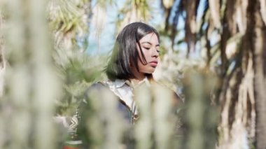 Pensive Young Native American Indian Girl connected with nature. Beautiful Indigenous girl looking at camera through the vegetation