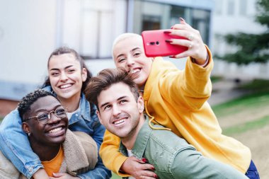 Mutlu Arkadaşlar Sırtüstü, gülerek ve cep telefonuyla selfie çekerek eğleniyorlar, genç etnik çiftler. Çeşitlilik Afrikalı Amerikan Gençliği