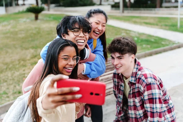 College Student Friends having fun laughing and taking a selfie photo on smartphone to celebrate friendship – stockfoto