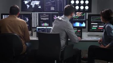 Ofiste Ekran Dijital Analizleriyle çalışan Mali Veri Analistleri Ekibi. Kadın Finans Uzmanı borsayı izliyor