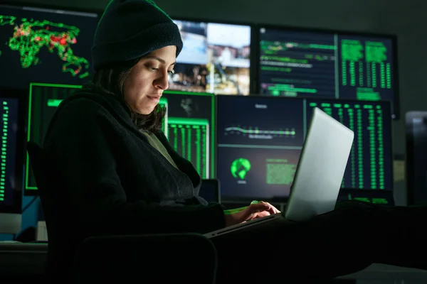 Female Hacker working in dark hidden hideout, attacking Company Data computer Servers and infecting system with Virus — kuvapankkivalokuva