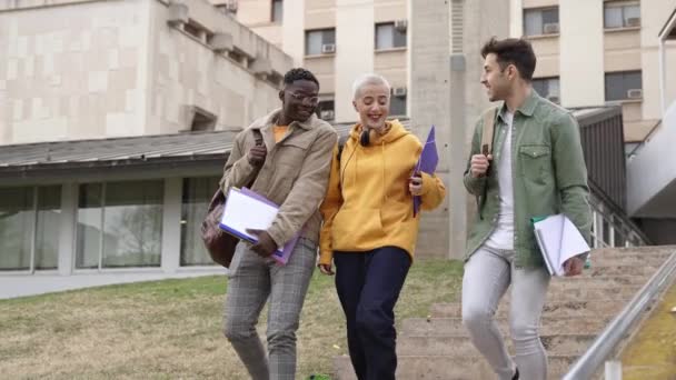 Universitätsstudenten, die mit Büchern und Schultaschen befreundet sind, reden und laufen auf dem College-Campus herum. Vielfalt in der Hochschulbildung — Stockvideo