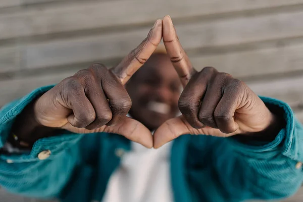 Musta Afrikkalainen Mies Makaa Maassa Tekemässä Käsitettä Ele Kehystää Kasvonsa — kuvapankkivalokuva