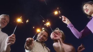 Mutlu olgun arkadaşlar yazın dışarıda havai fişeklerle eğleniyor.