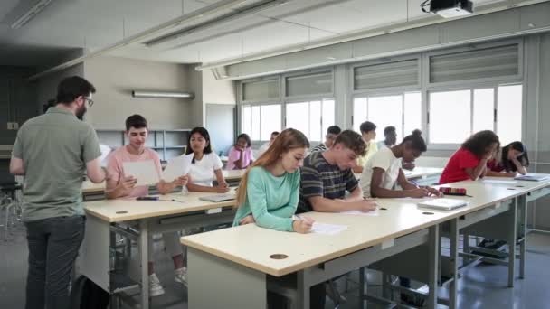 Young Teacher Giving Test Sheets Students Class Multi Ethnic Teenager — Stockvideo