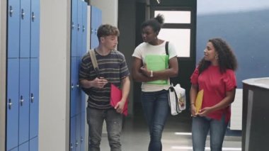 Multi ethnic confident and happy high school student friends going back to classes arriving to College, walking in the Hallway - Focus on the African Girl