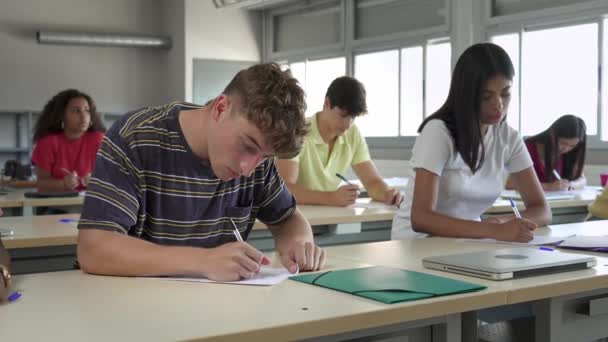 Tinédzser Férfi Diák Hallgatja Előadást Jegyzeteket Egy Osztályteremben Többnemzetiségű Tanulók — Stock videók