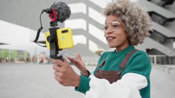 现代非洲裔美国女性影响者记录了一个视频Vlog与智能手机在城市的在线流媒体应用 — 图库视频影像