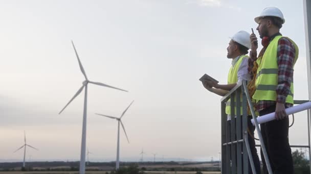 風力タービン発電所で働く2人の技術者 気候変動のための再生可能エネルギーソリューション — ストック動画