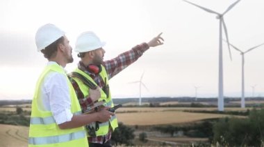 İHA uçuran mühendisler rüzgar türbinlerinin elektrik tarlalarını inceliyor ve kontrol ediyorlar. Bakım için hava teknolojisi kullanılıyor. 