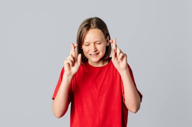 Lütfen, buna çok ihtiyacım var. Güzel esmer genç kız gergin hissediyor, şans dilemek için parmaklarını çapraz yapıyor, hayalleri gerçekleştiriyor, günlük kırmızı tişört giyiyor. Genç bayan bir şeyler umuyor.