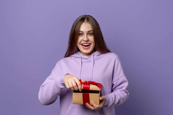Joven Mujer Sonriente Con Capucha Casual Púrpura Abriendo Regalo Envuelto —  Fotos de Stock