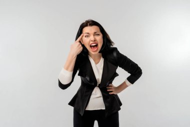 Siyah resmi ceketli iş kadını beyaz gömlekli kızgın agresif bir ifadeyle kameraya bakıyor kızgın, çılgın bir patron gibi görünüyor, beyaz arkaplan. İş konsepti