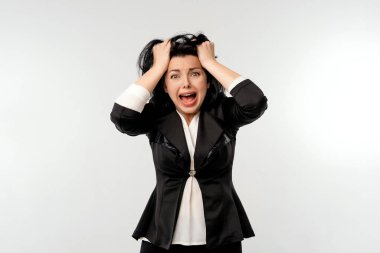 Küçük işletme sahipleri, kadın girişimciler konsepti. Şok olmuş iş kadını, siyah resmi ceketli beyaz gömlekli, paniklemiş, başını tutuyor ve endişeli yüzüyle ürkmüş görünüyor.