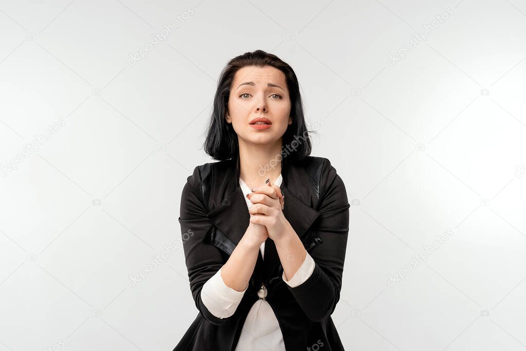 Worried businesswoman apologizing, making clingy sad face and pleading you, standing against white background. Business and praying concept