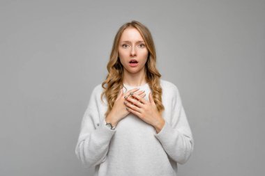 Hayır, çok kötü. Endişeli bir kadının portresi, çenesi düşük ve ellerini göğsüne dayamış, kaşlarını çatmış, gergin ya da gergin, tehlikede iken gri arka planda.