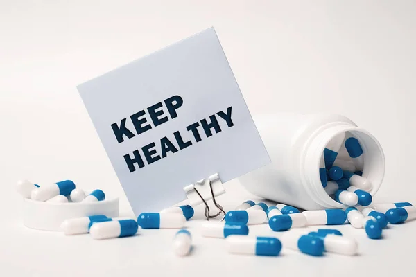 保持健康 写在蓝白药丸旁边的粘贴字条上 从药瓶中溢出 医疗概念 — 图库照片