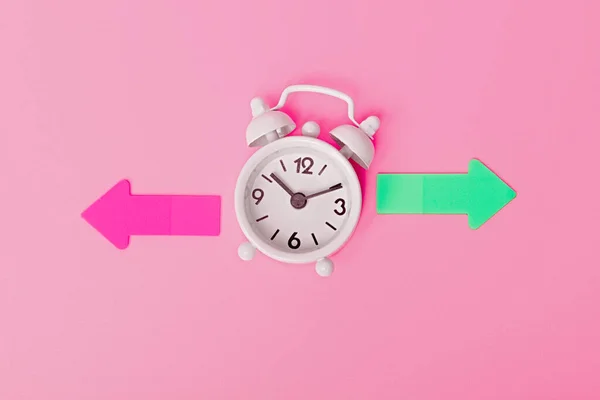 White Alarm Clock Colorful Arrows Pointing Right Left Pink Background — Stock Photo, Image