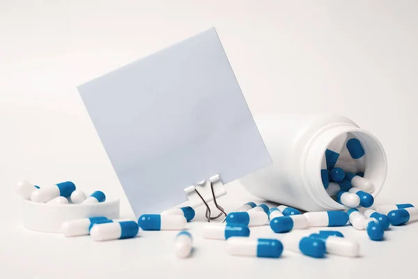 塞住一张空白的蓝色正方形的便条 蓝白色的药丸从药瓶里喷出 医学概念 未来重要活动通知的空白空间 — 图库照片